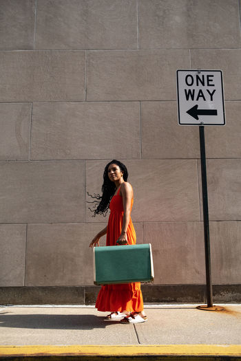 Full length of woman sitting on road
