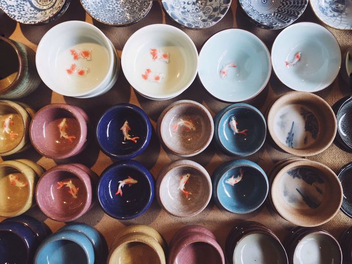 Directly above shot of artificial fish in colorful bowls
