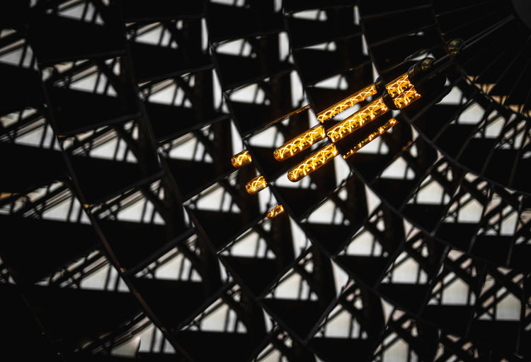 Low angle view of light painting on metal fence