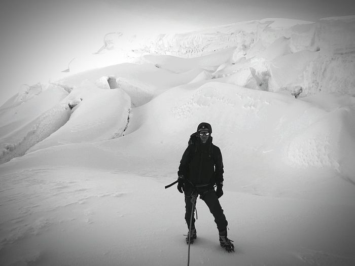 Full length of man standing on snowcapped mountain