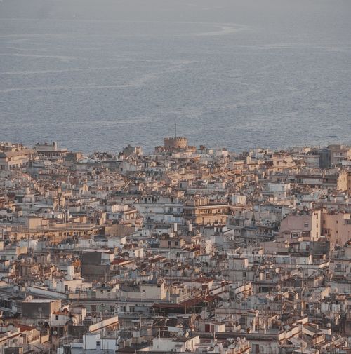 High angle view of townscape by sea against sky