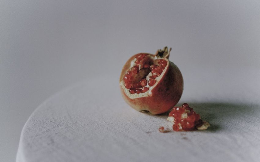 Close-up of pomegranate on table against white background