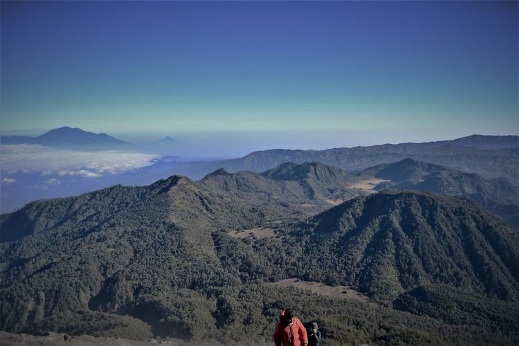 High angle view of men with mountain range in background against sky