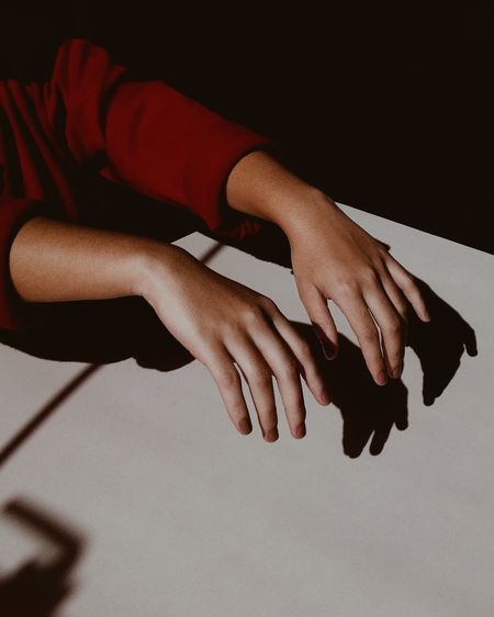 Midsection of woman making shadow with hands on table