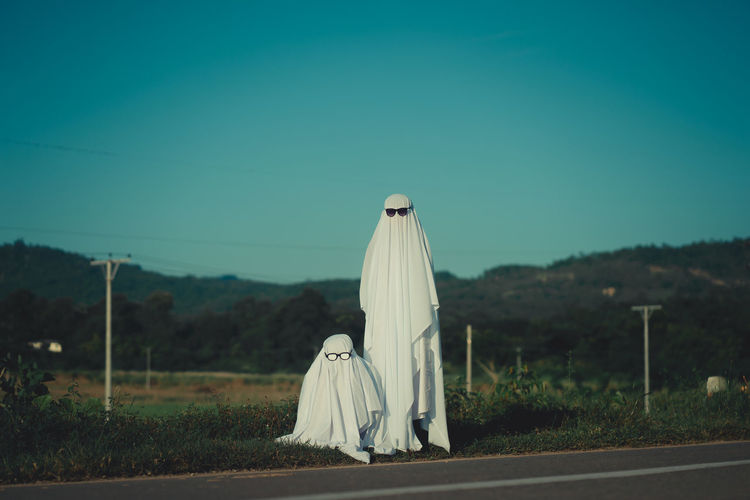 Friends wearing white dress standing near road