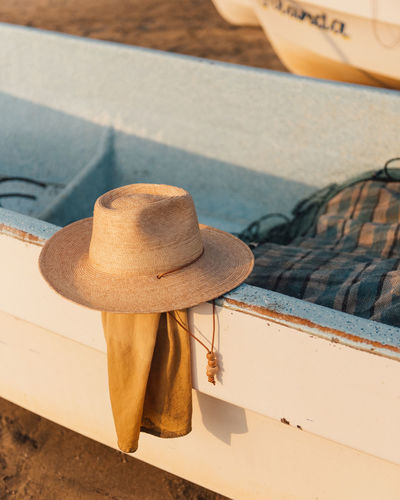 A traveller's hat rest along side a fishing boat