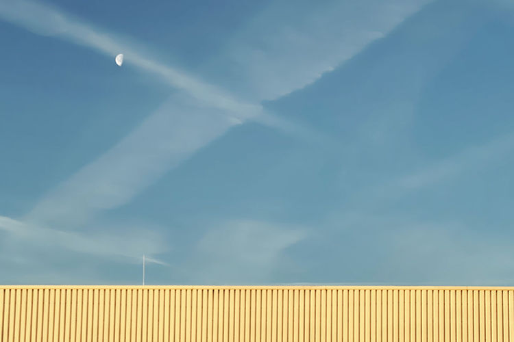 Low angle view of wall against blue sky
