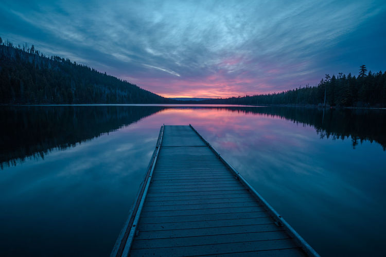 Scenic view of lake against sky at sunset