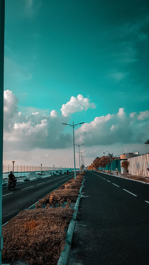 Road by street against blue sky