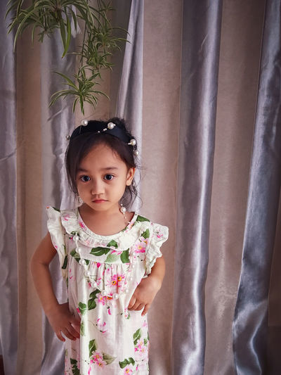 Cute girl against curtain at home