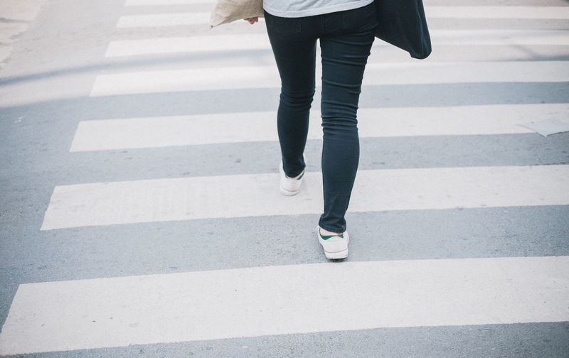 Low section of woman walking on road