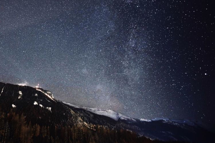 Low angle view of snowcapped mountains against sky at night