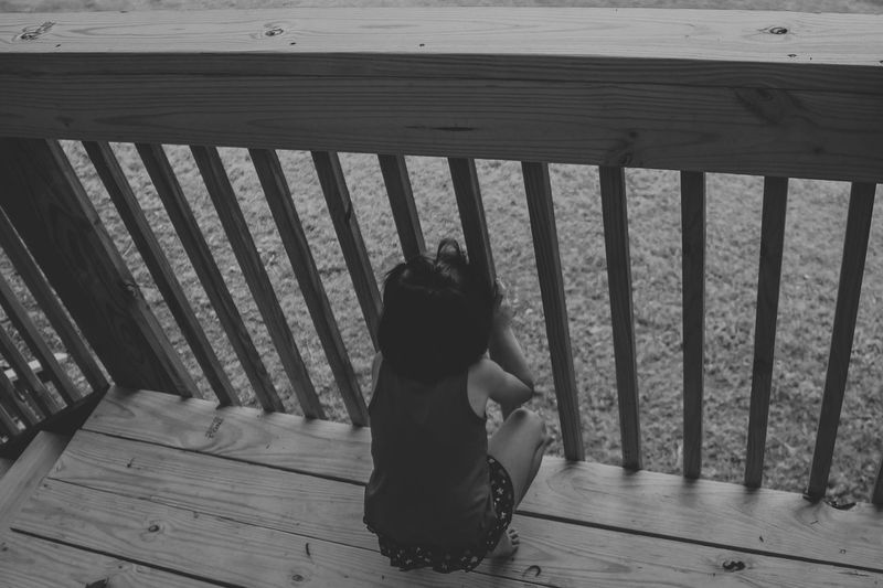 Boy sitting on wood