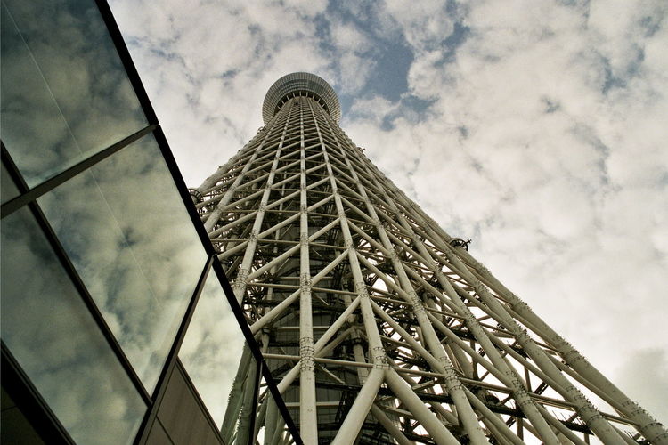 Low angle view of tokyo sky tree against cloudy sky in city