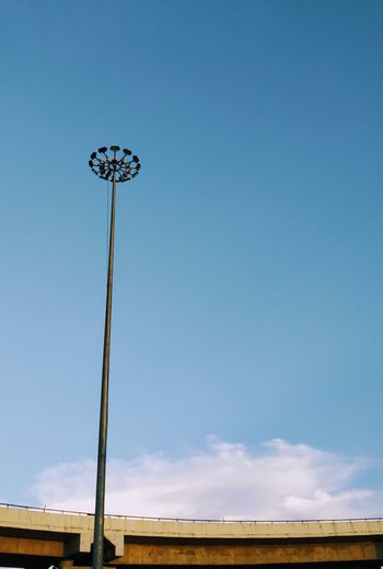 Low angle view of floodlight against blue sky