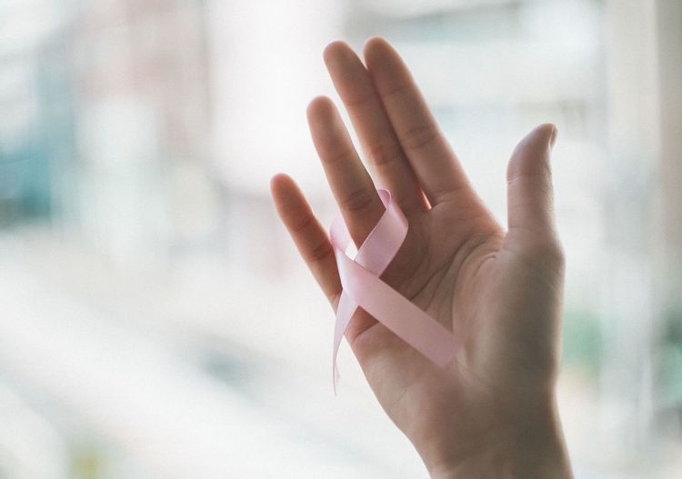 Close-up of woman hand and pink ribbon