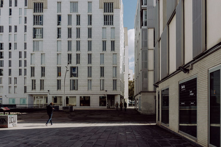 People walking on street amidst buildings in city