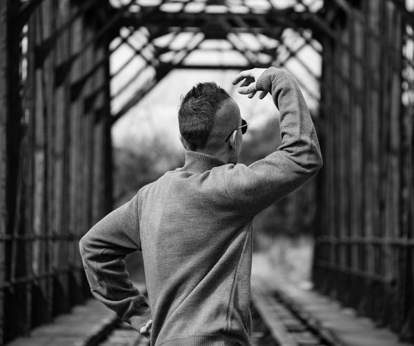 Man gesturing while standing on railroad track
