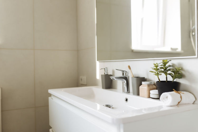 Washbasin in white bathroom with bath accessories. hotel cleaning concept. household concept