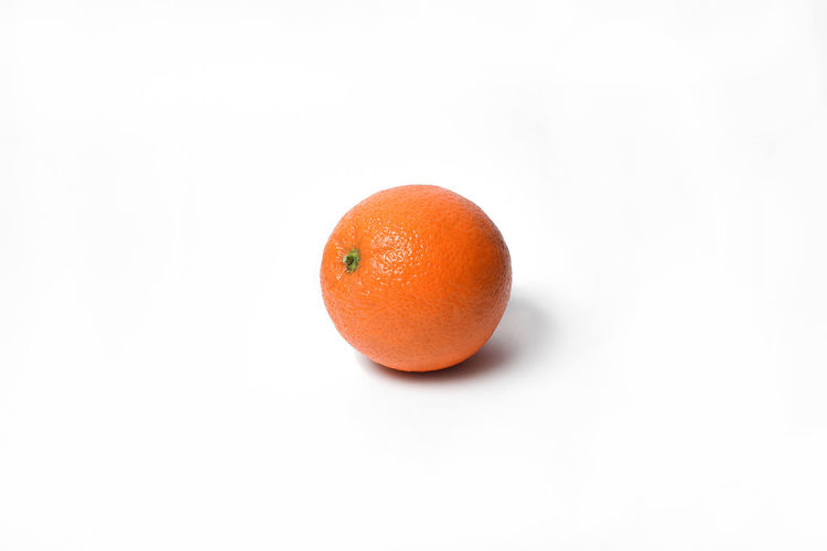 Close-up of orange apple against white background