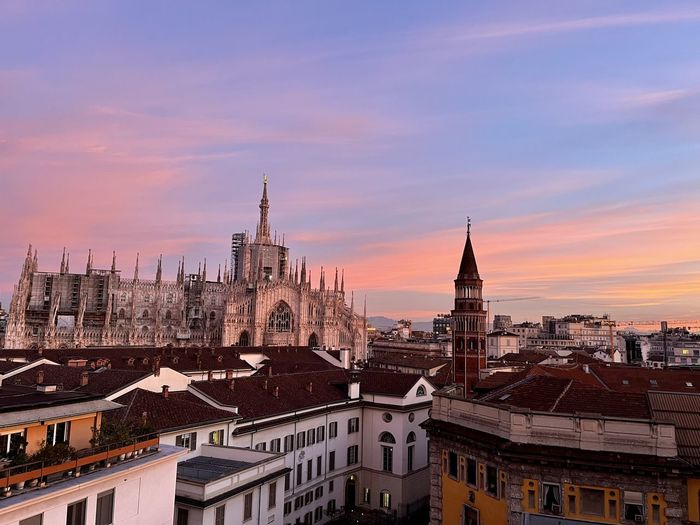 Buildings in city against sky during sunset