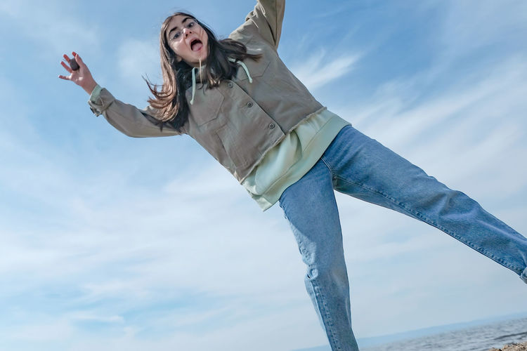 Low angle view of young woman standing against sky in turkey