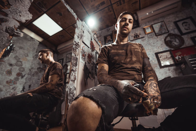 Full length of man holding tattoo machine