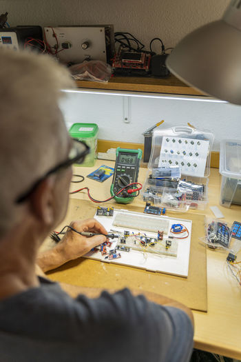 Senior man working on electronic circuits in his workshop