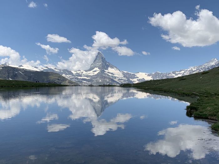 Scenic view of lake by mountain against sky