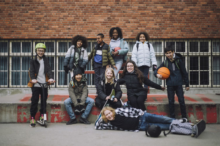 Portrait of diverse students enjoying in front of school building