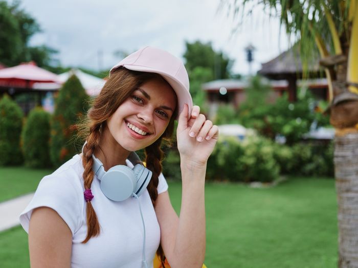 Portrait of young woman wearing hat standing outdoors