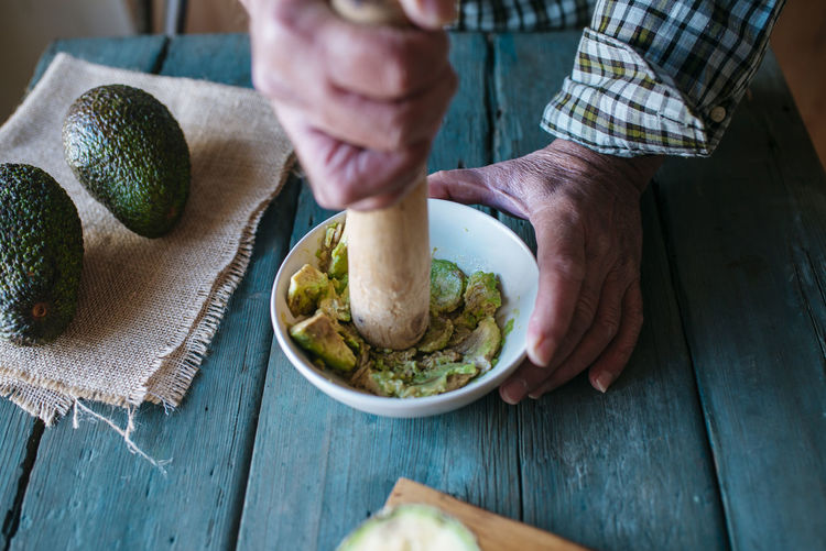 Hands of man mashing avocado for guacamole