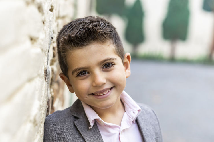 Portrait of smiling boy by wall