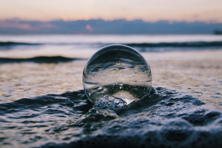 Close-up of crystal ball on beach
