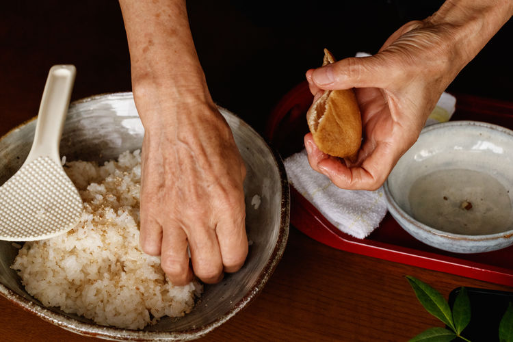 Cropped hand of woman preparing food on table.