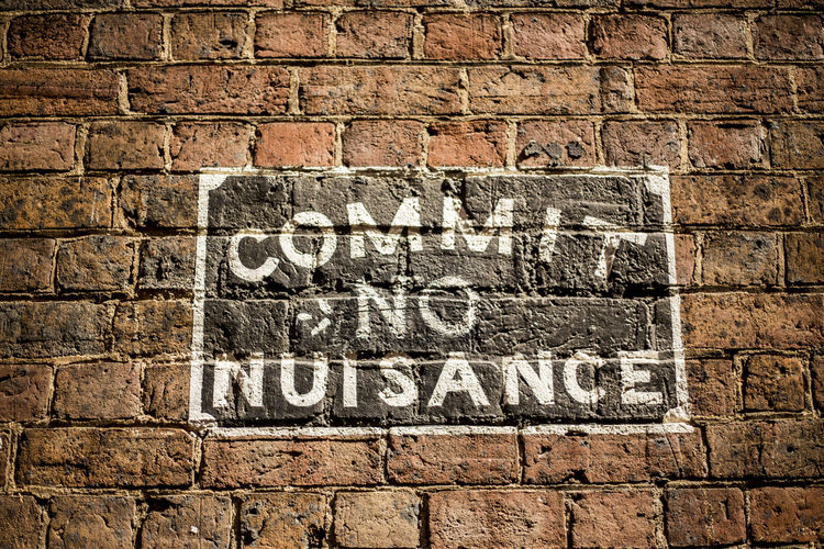 Low angle view of text on brick wall