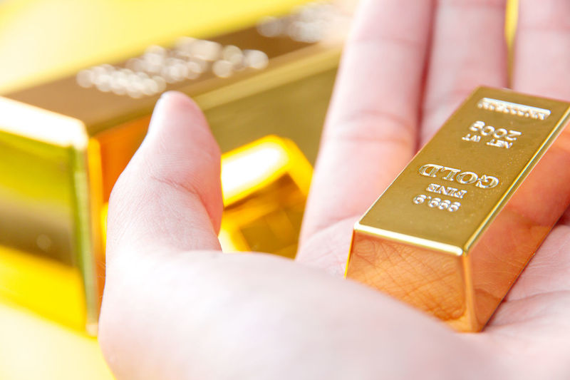 Close-up of hand holding gold bar