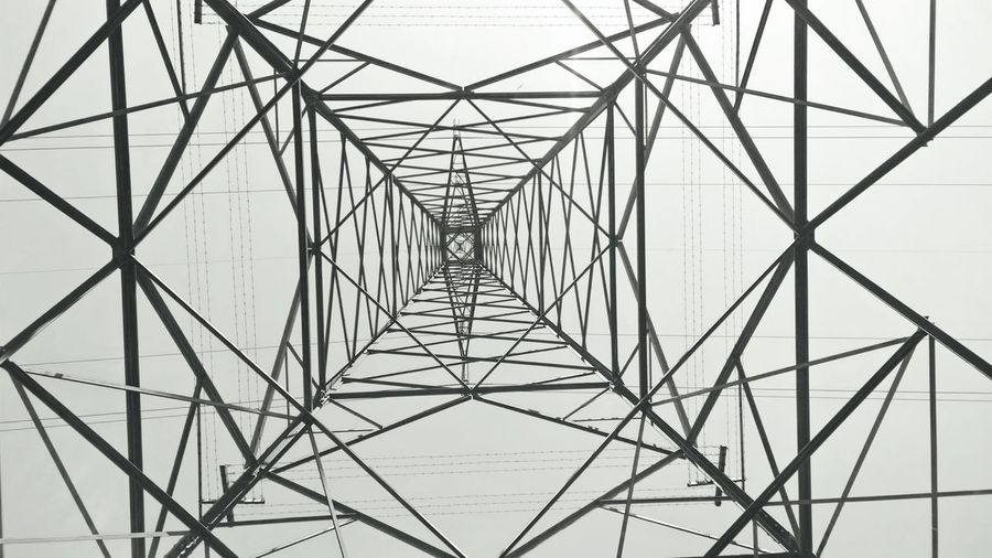 Directly below shot of electricity pylon against sky