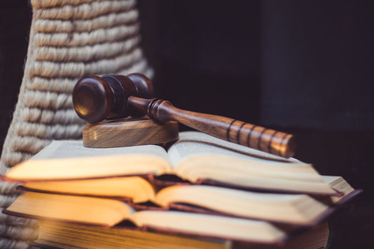 Close-up of gavel on stacked books at table