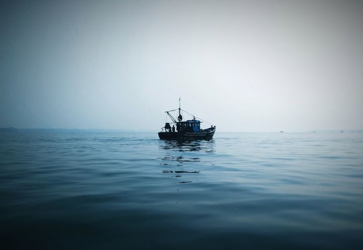 Sailboat in sea against clear sky