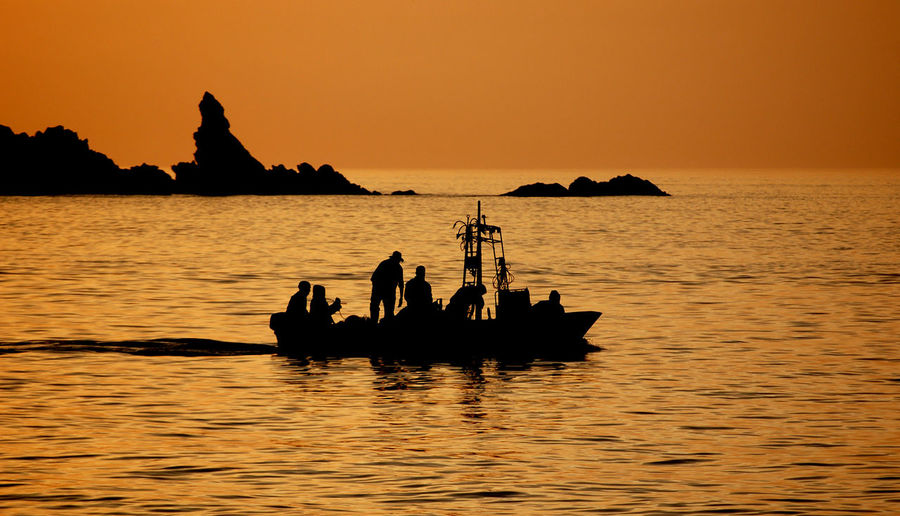 Fishermen working in golden evening light.