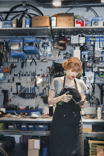Female mechanic repairing pedal in workshop
