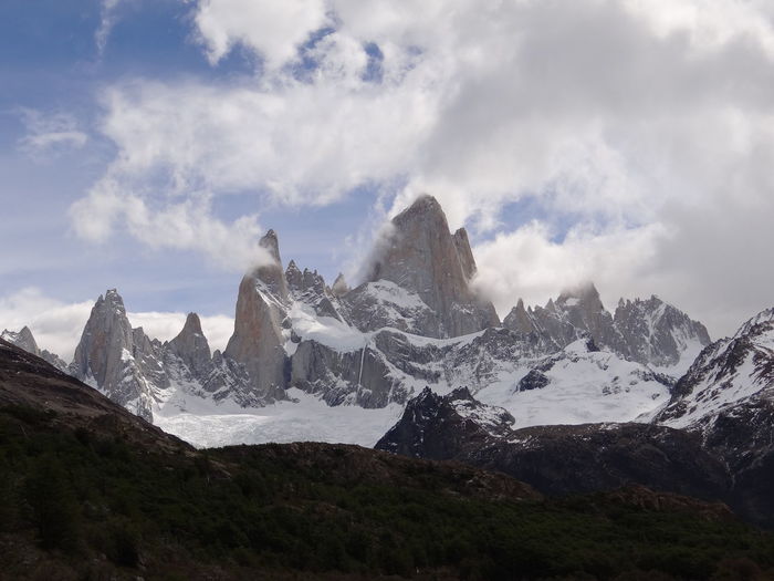 Scenic view of snowcapped mountains against cloudy sky