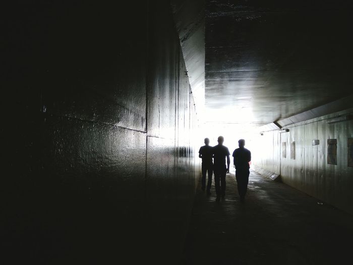 Silhouette people standing in tunnel