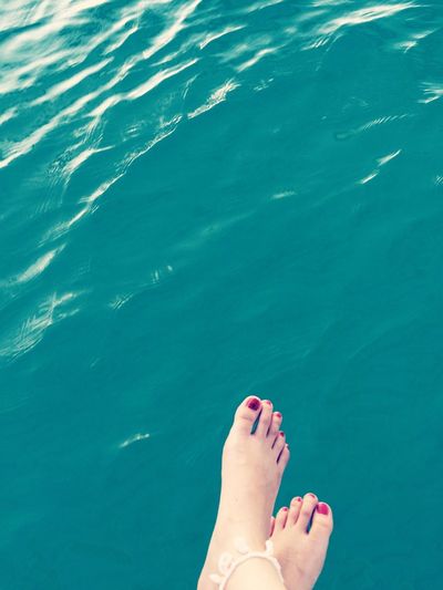 Low section of woman legs against sea