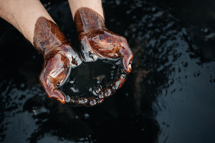 Close-up of hand holding crude oil