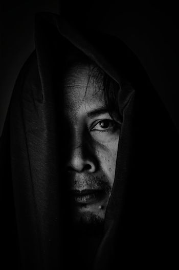 Portrait of mid adult man against black background