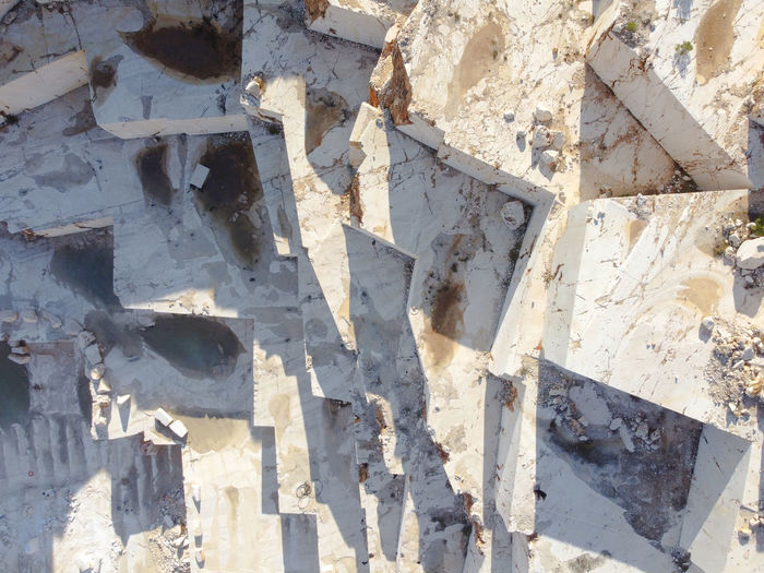 Terraces of cut stone material at marble quarry. marble quarry sledges top down aerial view