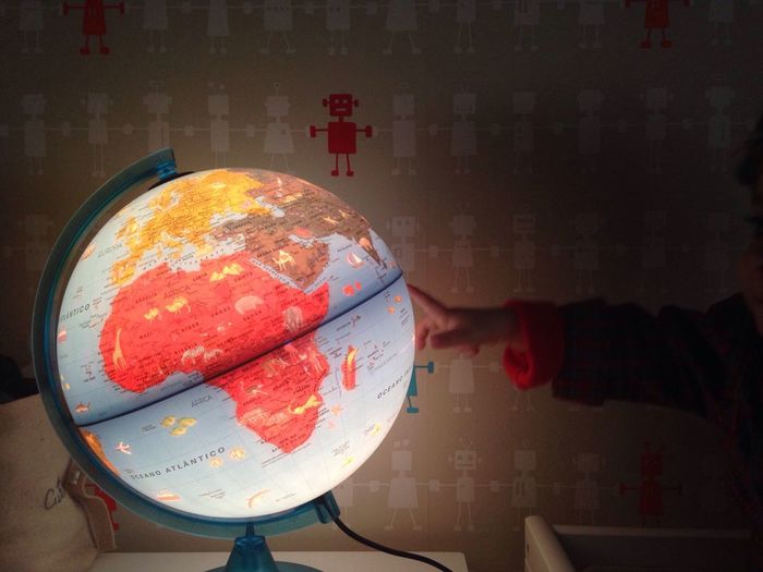 Cropped image of child touching illuminated globe