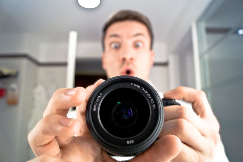 Portrait of surprised man holding camera